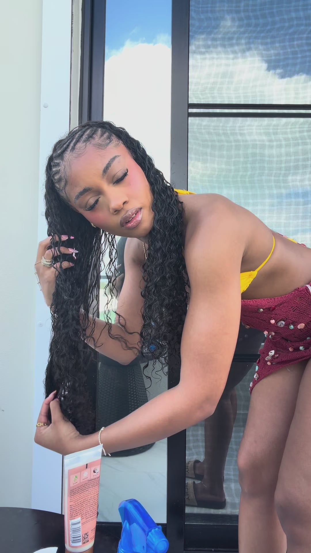 Woman in a red and yellow dress standing outdoors with a building in the background